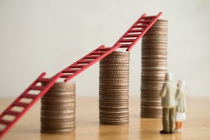 Love old senior couple looking at growth stack coins graph chart with red ladder. Financial planning for retirement, savings, pension, gain return on investment, wealth and so on concept.